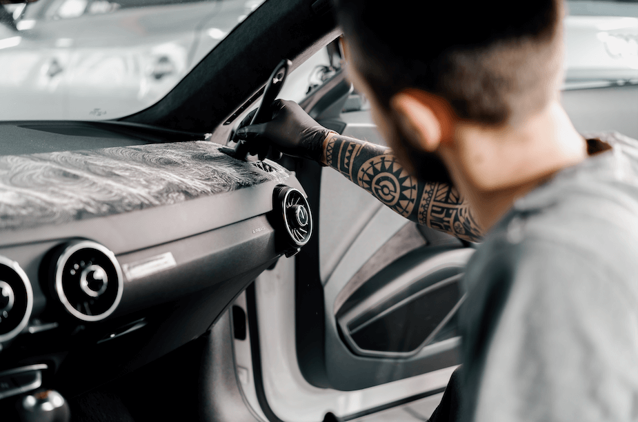 man dusting a car dashboard